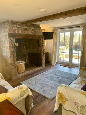 a living room with a stone fireplace and a couch at The Old Smithy, beautifully restored cottage in Carreghofa, near Llanymynech in Llanymynech