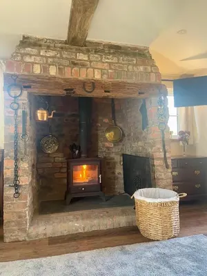 a stone fireplace in a living room with a fire place at The Old Smithy, beautifully restored cottage in Carreghofa, near Llanymynech in Llanymynech