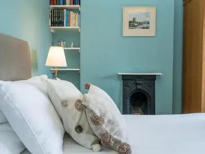 a bedroom with a bed with pillows and a fireplace at Quintessentially English 3-Bed Home in Ludlow - Pass the Keys in Ludlow
