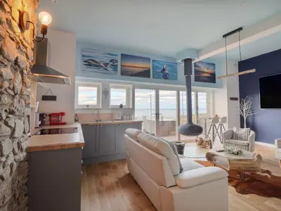 a living room with a couch and a kitchen at Bermo Cwtch in Barmouth