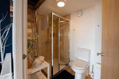a small bathroom with a toilet and a shower at Bermo Cwtch in Barmouth