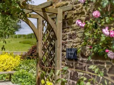 a wooden gate to a garden with a sign that reads happy anniversary at Robin's Nest in Craven Arms