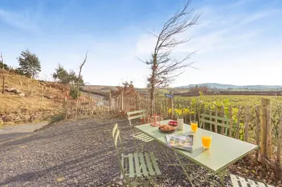 a table and chairs on a dirt road with a fence at 1 Bed in Ffestiniog oc-c31093 in Ffestiniog