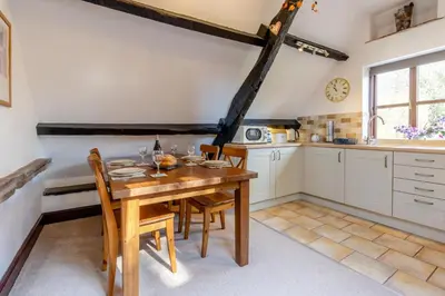 a kitchen with a wooden table and wooden chairs at 2 Bed in Llangorse oc-p31754 in Llangorse