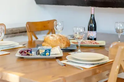 a wooden table topped with plates and glasses of wine at 2 Bed in Llangorse oc-p31754 in Llangorse