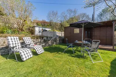 a yard with two chairs and a table with an umbrella at 2 Bed in Llangorse oc-p31754 in Llangorse