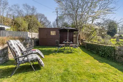 a yard with two chairs and a table with an umbrella at 2 Bed in Llangorse oc-p31754 in Llangorse