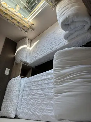 two beds in a room with white sheets and pillows at Coastal Serenity Escape Clarach Bay Sea Viev Modern 2019 model No Pets in Aberystwyth