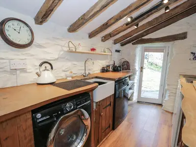 a kitchen with a dishwasher and a clock on the wall at Old Ty'n Y Wern in Bala