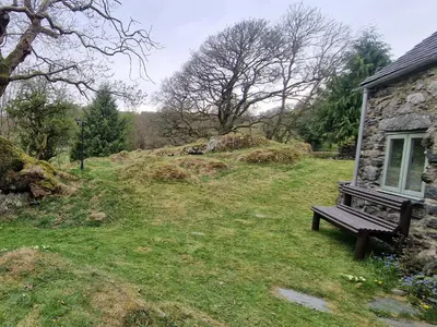 a bench sitting in the grass next to a house at Old Ty'n Y Wern in Bala