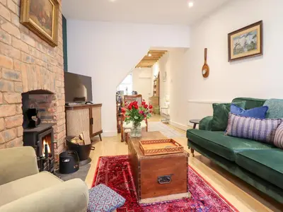 a living room with a couch and a fireplace at Derwen House in Llangollen