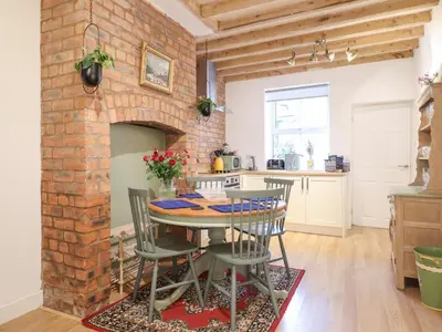 a kitchen and dining room with a brick wall at Derwen House in Llangollen