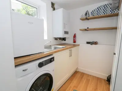 a washing machine in a kitchen with a sink at Derwen House in Llangollen