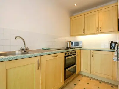 a kitchen with wooden cabinets and a sink at Tegawelon in Harlech