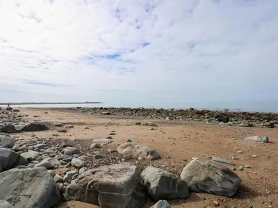 a beach with rocks and the ocean in the background at Tegawelon in Harlech