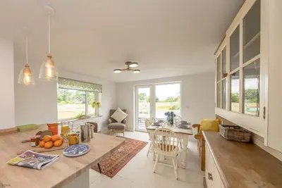 a kitchen and living room with a table and chairs at Glanaber in Dyffryn