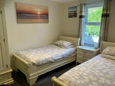 a bedroom with two twin beds and a window at Blue Lodge - by the sea, sauna, BBQ, private garden and parking in Aberystwyth