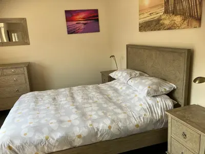 a bedroom with a bed and two dressers at Blue Lodge - by the sea, sauna, BBQ, private garden and parking in Aberystwyth