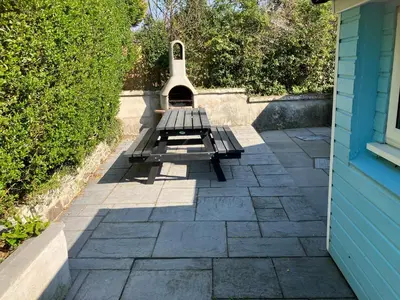 a bench sitting next to a blue house at Blue Lodge - by the sea, sauna, BBQ, private garden and parking in Aberystwyth