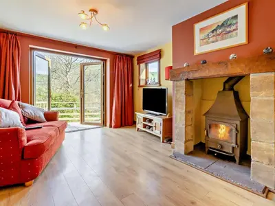 a living room with a fireplace and a red couch at 4 Bed in Llanidloes oc-95968 in Van