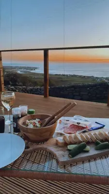 a table with a bowl of food and a view of the ocean at coastal view shepherds hut with hot tub in Llanfair