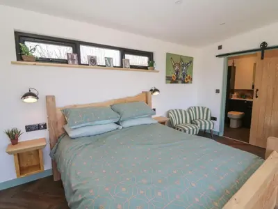 a bedroom with a bed with a blue comforter at Llety Cariad in Llandrindod Wells