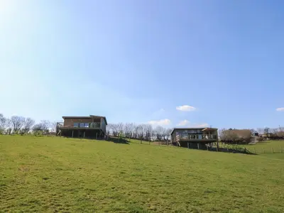 two houses on a hill in a field at Llety Cariad in Llandrindod Wells