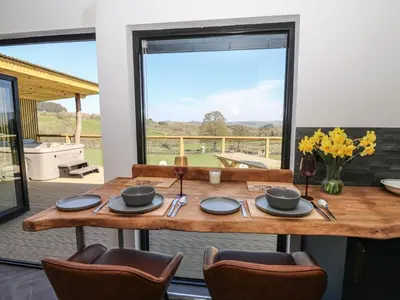 a dining room with a table and chairs and a large window at Bryn Hafod in Llandrindod Wells