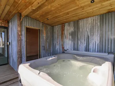 a large bath tub in a room with a wooden ceiling at Bryn Hafod in Llandrindod Wells