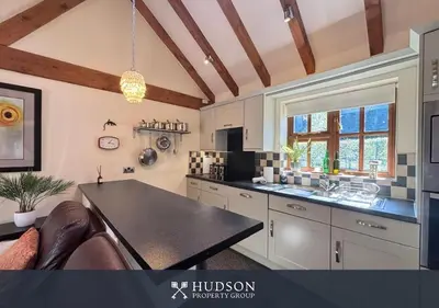 a kitchen with white cabinets and a black counter top at Private Cottage in Shrewsbury in Shrewsbury