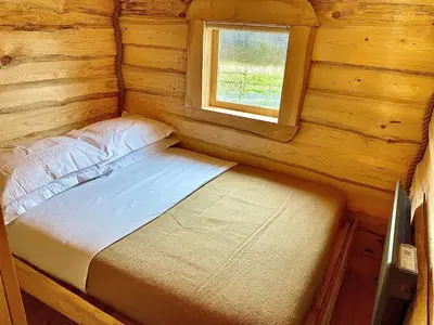 a small bed in a log cabin with a window at The Viking Lodge with Sauna in Ystrad-Meurig