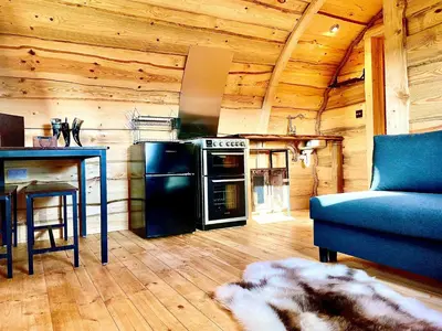 a living room with a stove and a blue couch at The Viking Lodge with Sauna in Ystrad-Meurig
