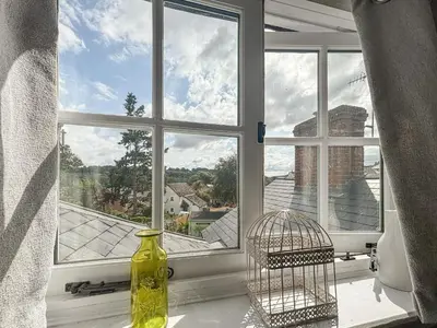 a window with a yellow vase and a bird cage at Flo's Cottage in Kington