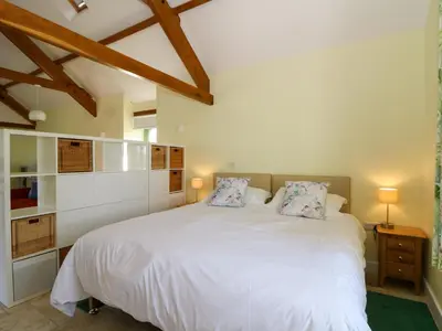 a bedroom with a large white bed with two pillows at Cwtch in Ystrad Meurig