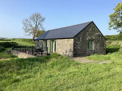 a small stone building in a grassy field at Cwtch in Ystrad Meurig