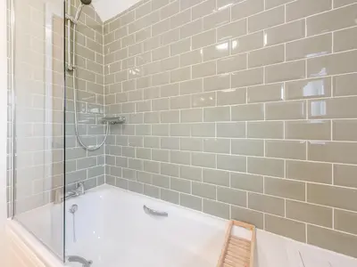 a white bathroom with a tub and a shower at Yr Encil in New Quay