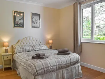 a bedroom with a bed with two towels on it at Yr Encil in New Quay
