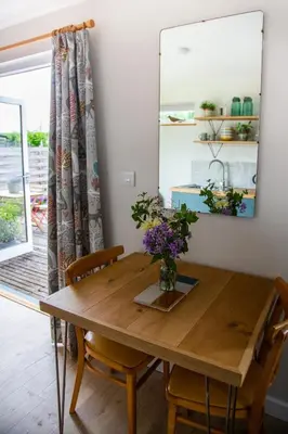 a dining room table with chairs and a mirror at Beautiful Cabin Near Hay-on-Wye in Peterchurch