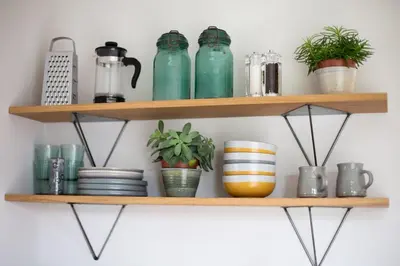 a shelf with green jars and plants on it at Beautiful Cabin Near Hay-on-Wye in Peterchurch