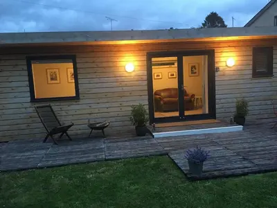a house with a porch with a couch on a deck at Beautiful Cabin Near Hay-on-Wye in Peterchurch