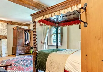 a bedroom with a canopy bed and a window at Beautiful Brecon Beacon House in Llandovery