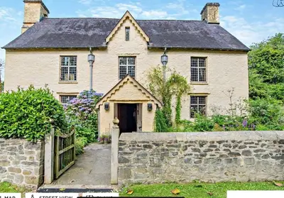 a large white house with a stone wall at Beautiful Brecon Beacon House in Llandovery