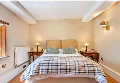 a bedroom with a bed with two night stands and two lamps at Beautiful Brecon Beacon House in Llandovery
