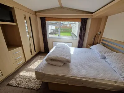 a small bedroom with two beds and a window at The Beach Hideaway Pet Friendly 2 Bedroom Static Caravan Clarach Bay in Aberystwyth