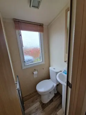 a small bathroom with a toilet and a window at The Beach Hideaway Pet Friendly 2 Bedroom Static Caravan Clarach Bay in Aberystwyth