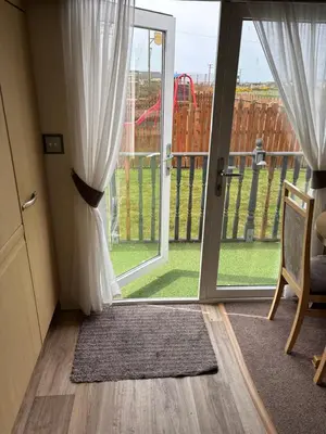 a sliding glass door with a view of a playground at The Beach Hideaway Pet Friendly 2 Bedroom Static Caravan Clarach Bay in Aberystwyth