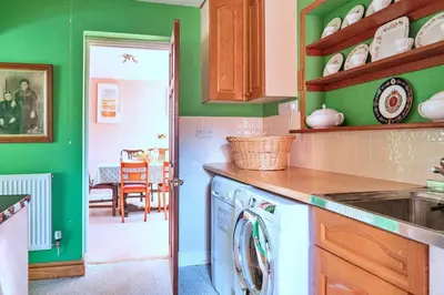 a kitchen with green walls and a washing machine at Finest Retreats - Cwmfron House in Llanidloes