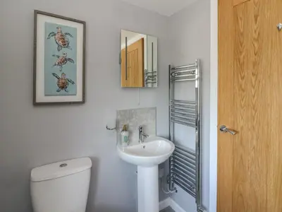 a bathroom with a white toilet and a sink at Curtau in Builth Wells