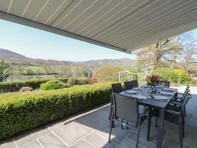 a dining table under a canopy on a patio at Curtau in Builth Wells