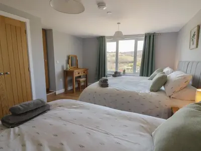 a bedroom with two beds and a window at Curtau in Builth Wells